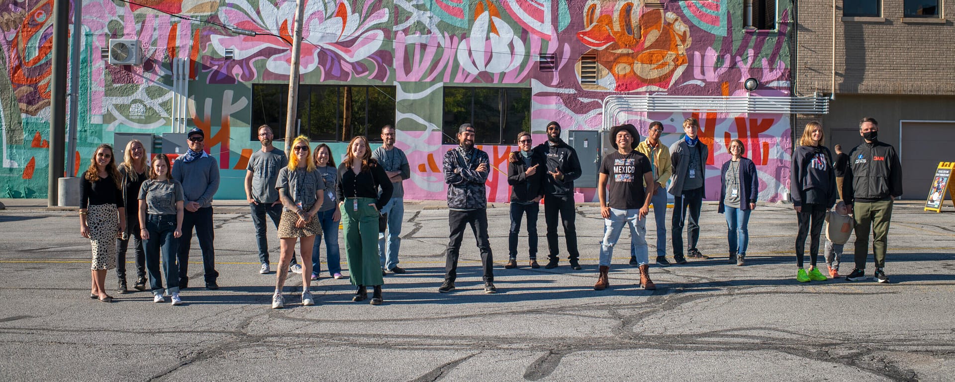 A photo of the Mural Fest artists in front of a mural.